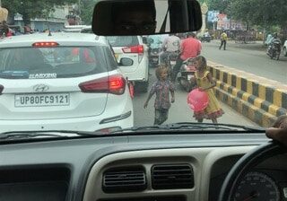 Children selling balloons to drivers at a busy intersection in Kolkata 
